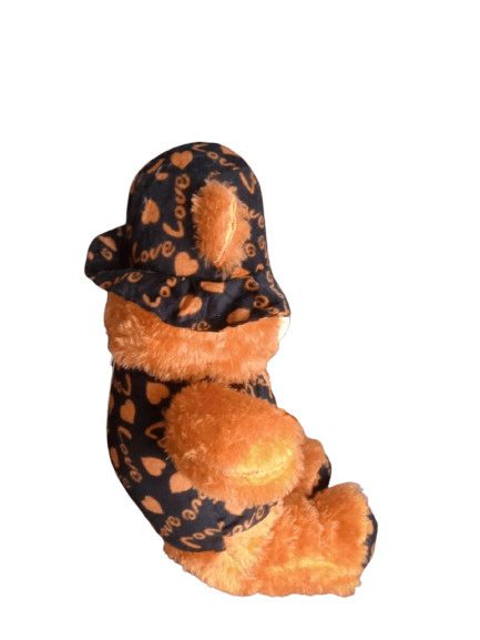 Cute and cuddly brown teddy bear wearing a hat and shirt with love heart pattern