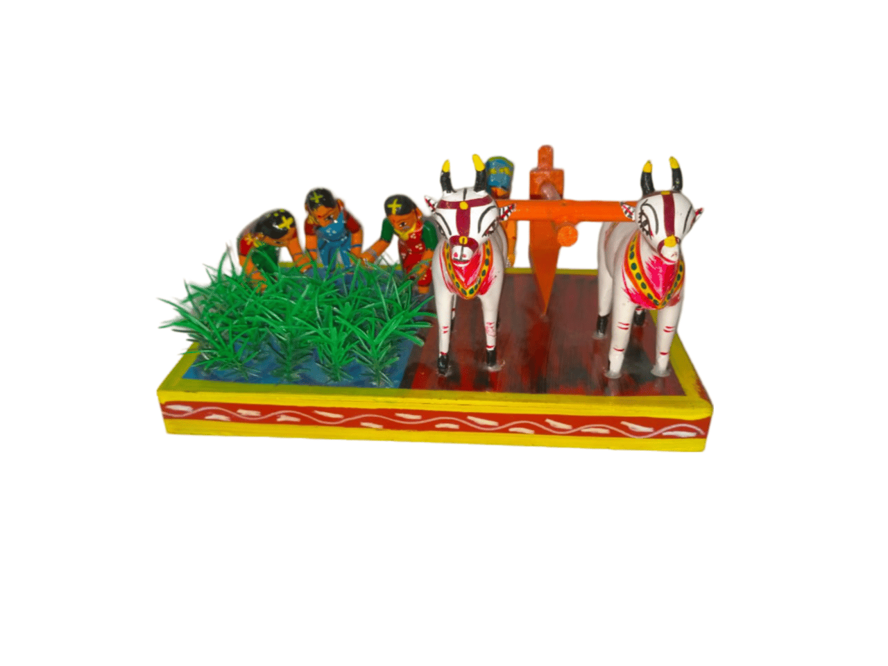 Wooden figurine of a farmer plowing a field with a pair of oxen, and two women planting crops.