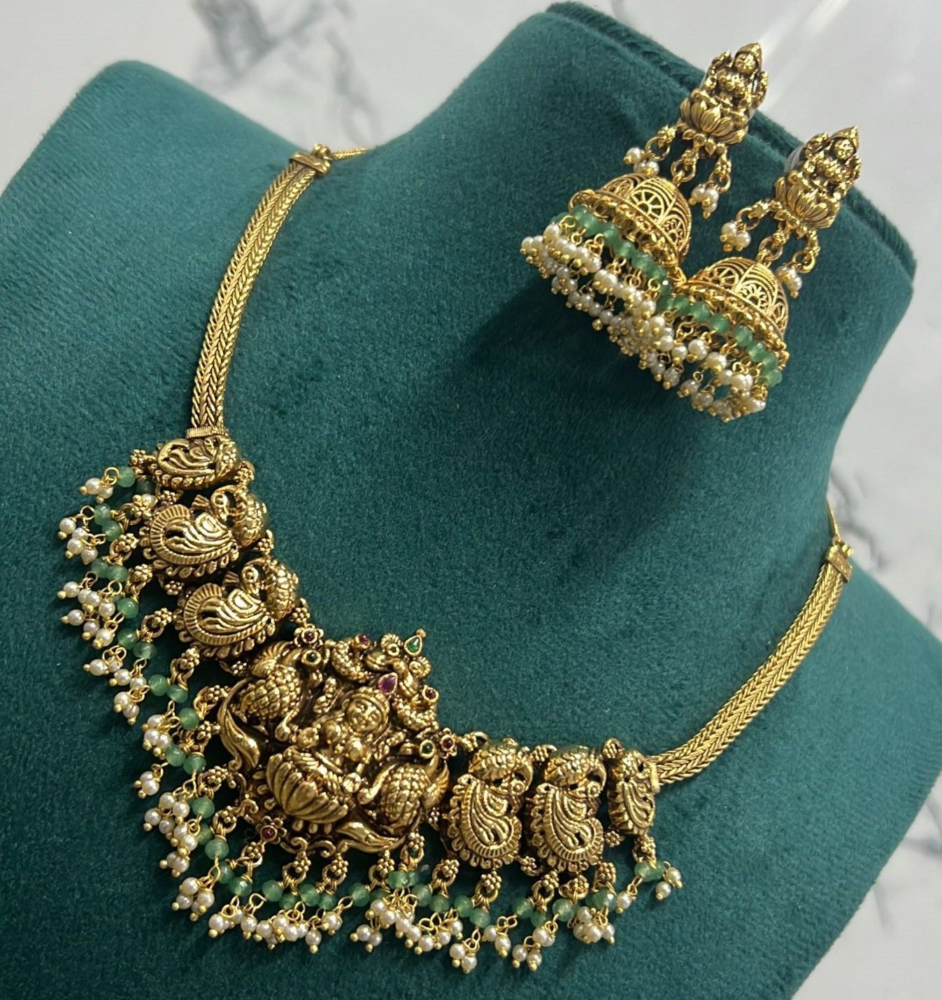 Gold-plated antique finish Lakshmi temple necklace set with green stones and pearls