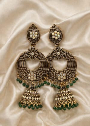Vardaan Crystalx premium traditional Indian jhumka earrings with a striking antique bronze-gold finish, adorned with shimmering iridescent AB rhinestones and rich emerald-green bead cascades. 