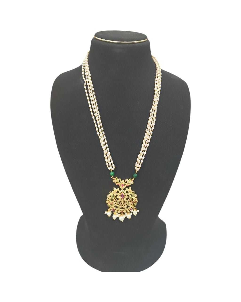 Pearl and gold necklace with intricate detailing and a floral pendant.
