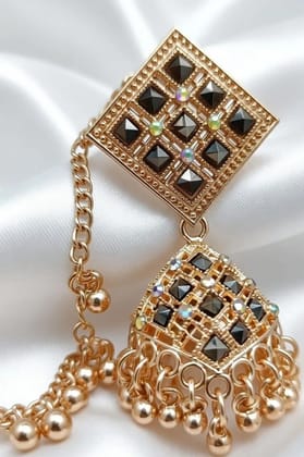 Vardaan Crystalx Earing with chain is a elegant gold-tone jhumka earring with side chain, featuring black stone detailing and delicate ghunghru drops perfect for every women in every traditional and festive season. Vardaan Crystalx Earing with chain is a elegant gold-tone jhumka earring with side chain, featuring black stone detailing and delicate ghunghru drops perfect for every women in every traditional and festive season.